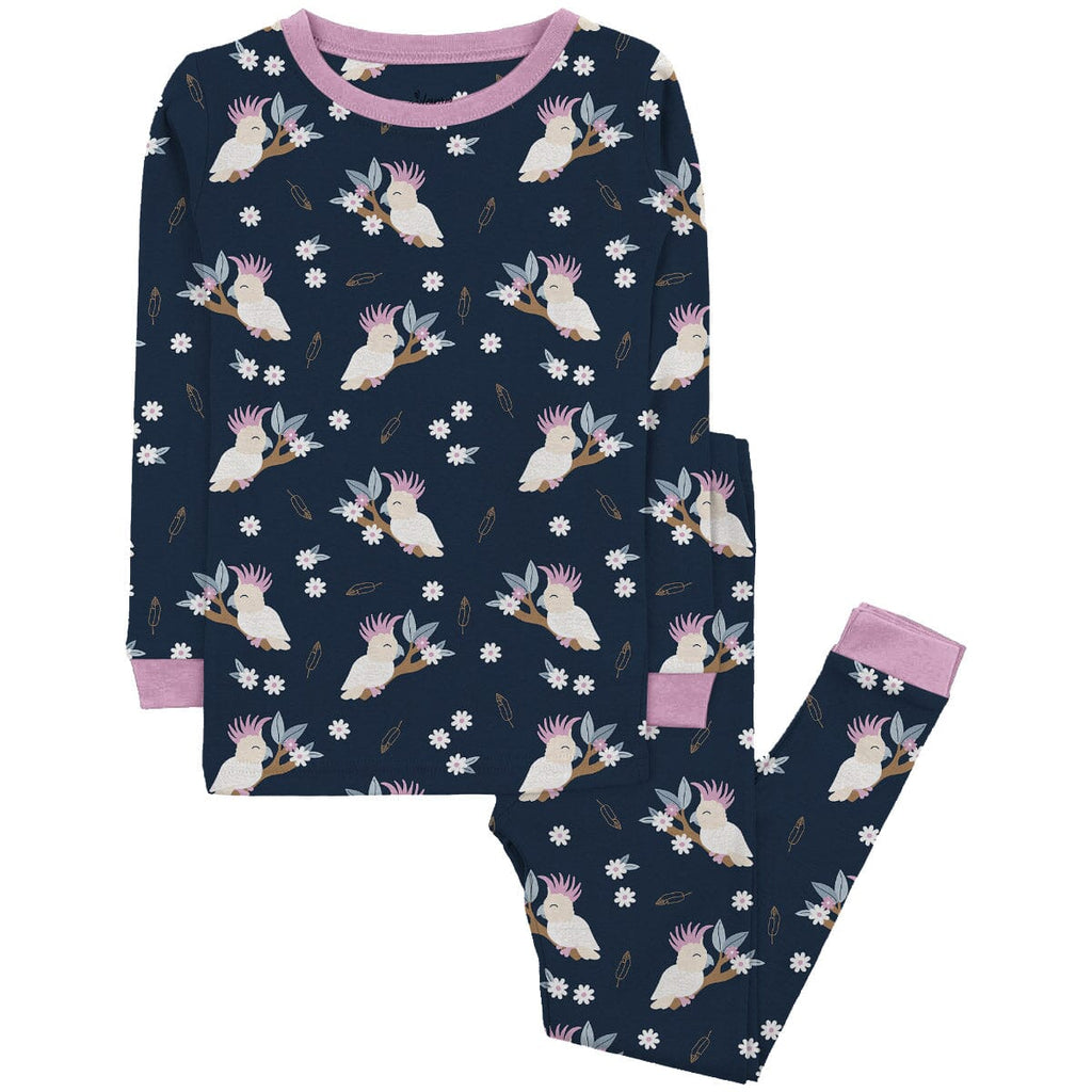 Tweet Dreams Jams Big Kids a  dark blue pajama set  a playful pattern of white parrots with colorful crests in shades of pink, perched on branches with green leaves and pink flowers. Scattered among the parrots are small white flowers and brown feathers. The pajama has a  pink cuffs matching pink neckline. on the sleeves and legs. The pajama pants feature an pink  trim. The set is displayed against a plain white background