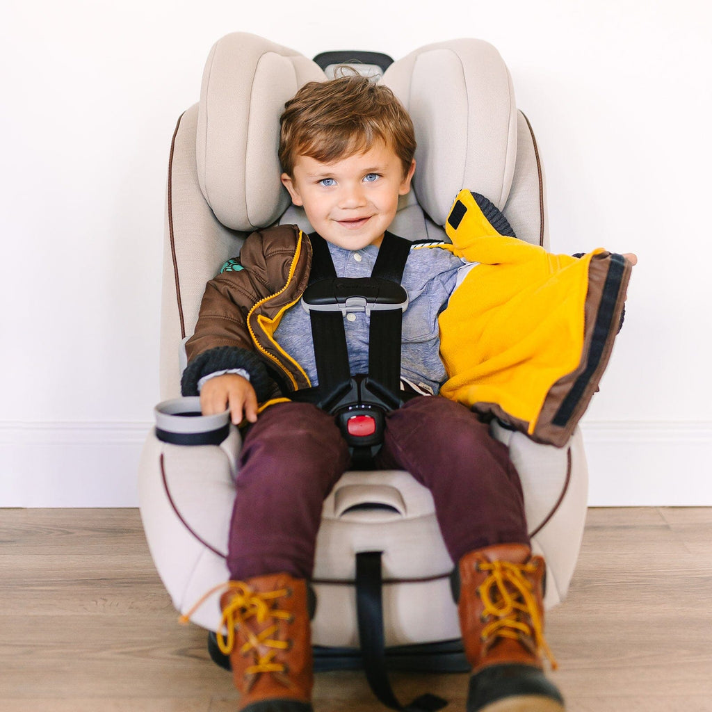 Snickerdoodle/Brown
Little boy with brown hair and blue eyes is wearing a brown car seat coat.  The coat is unzipped showing the buckled harness.  The boy is smiling at the camera.